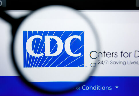 Magnifying glass over CDC logo on a website.