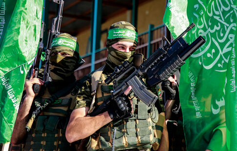 Two armed masked soldiers with green flags.