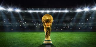 Golden trophy on soccer field under stadium lights