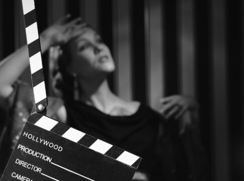 Black and white scene with clapboard and performer.