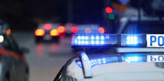 Police car with flashing blue lights on street.