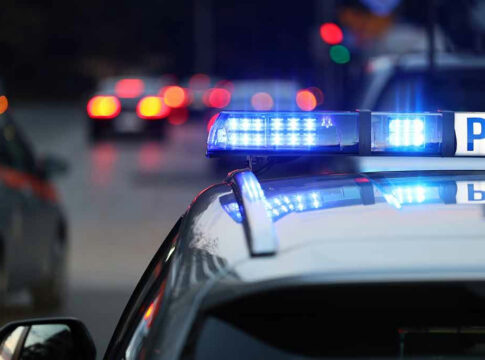 Police car with flashing blue lights on street.